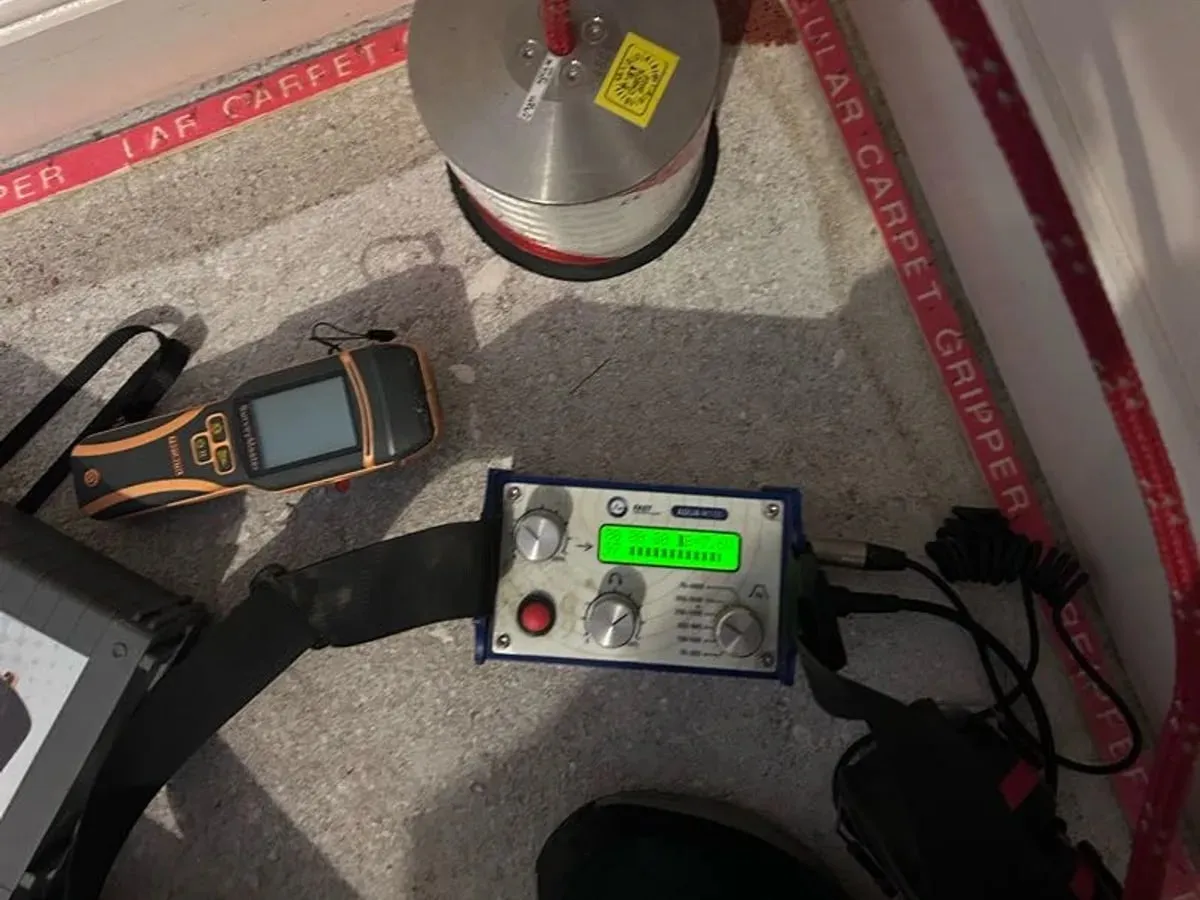 Acoustic listening unit with a green display and ground microphone on a carpeted floor