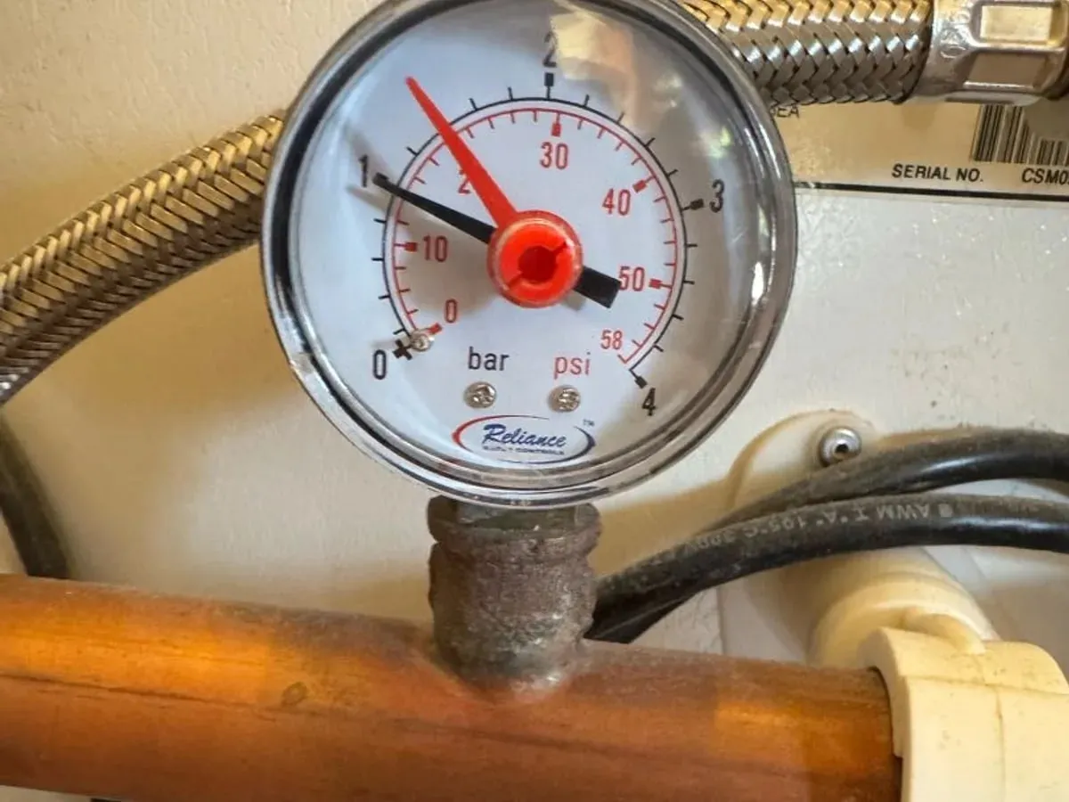 Pressure gauge fitted to a copper pipe on the hot supply